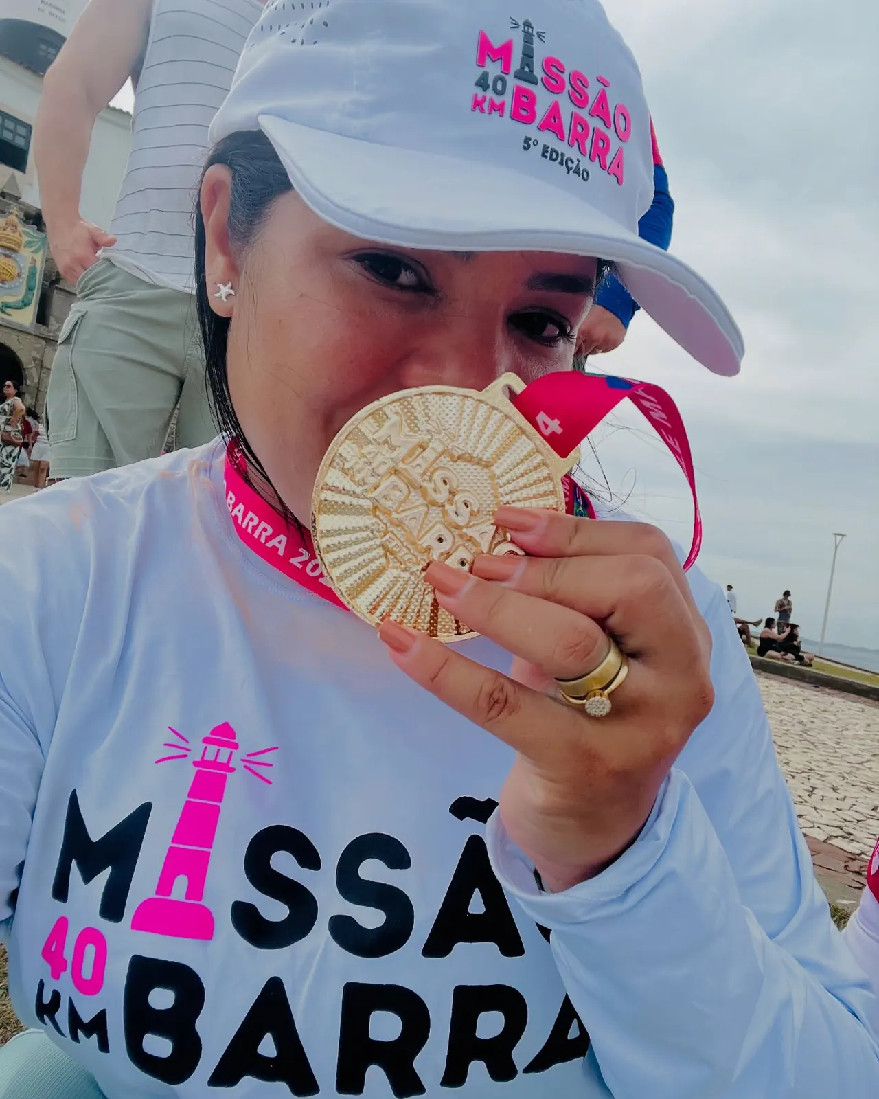 Participante da 5ª edição mordendo a medalha