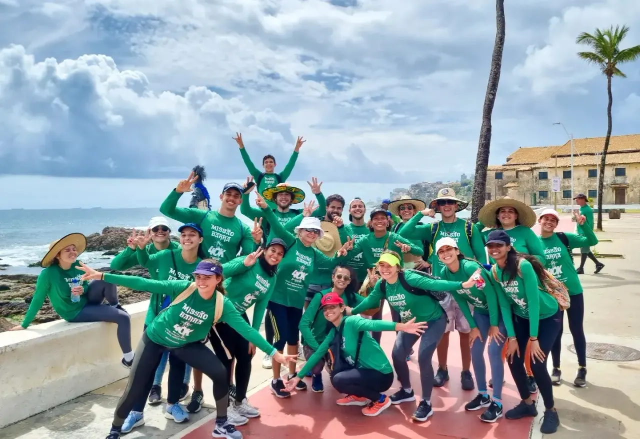 Participantes da 3ª edição, de camisa verde, comemorando juntos na orla de Salvador